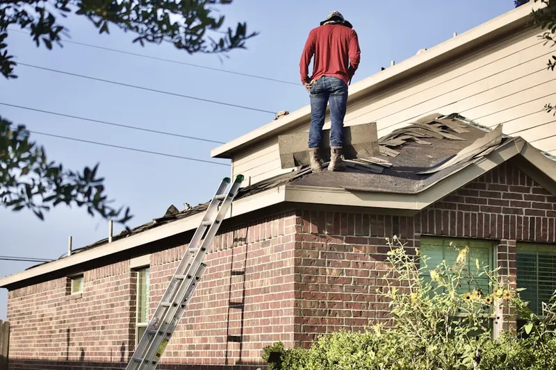 Professional roofer working on a residential roof in D'Iberville